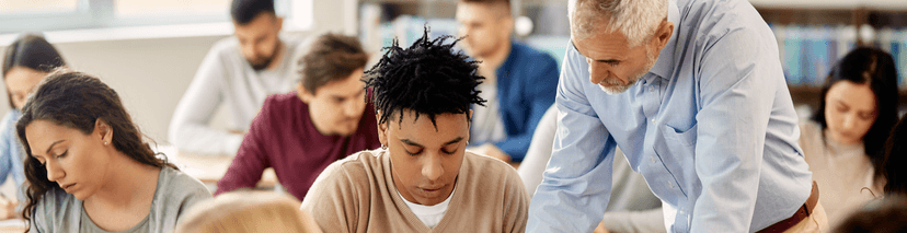 Young Black Student in a Classroom Asking his Teacher for Help.